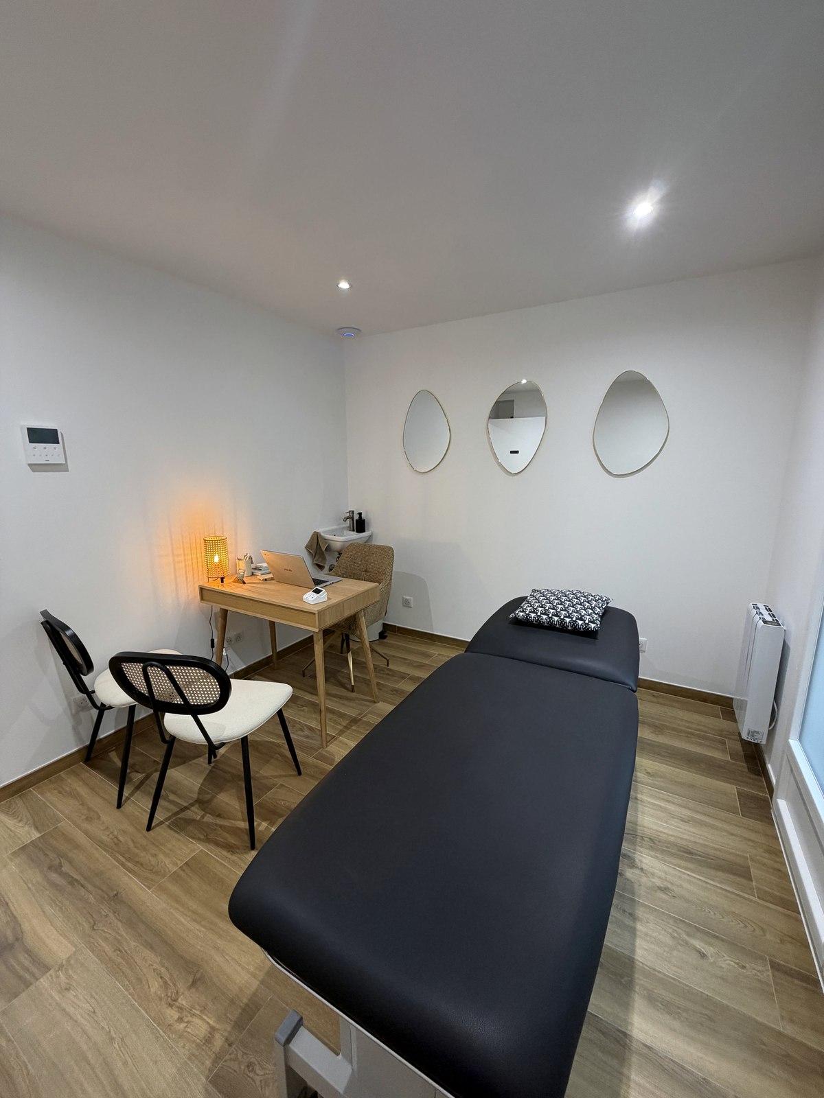 La table d'ostéopathie et le bureau, dans la lumière chaleureuse du cabinet