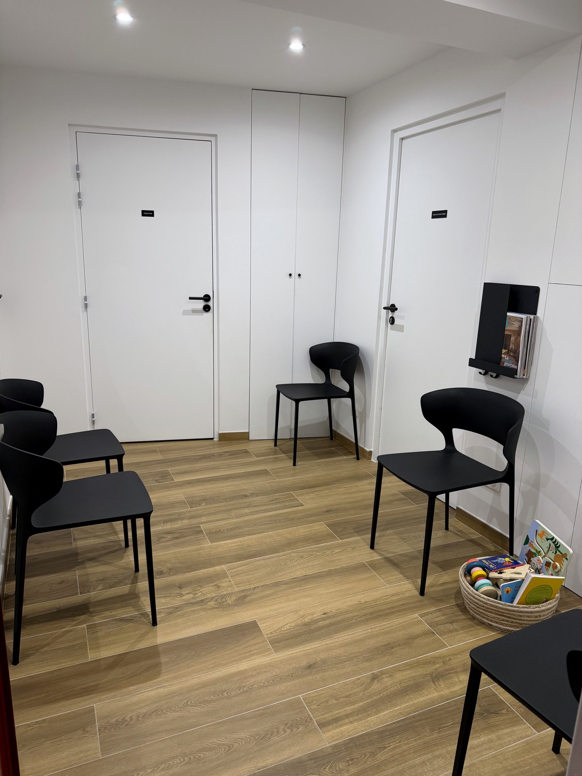 La salle d'attente du cabinet : chaises, parquet chaleureux et panier de jouets pour les enfants